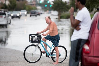 Un hombre atraviesa en bici una zona inundada en Conway, Carolina del Sur.