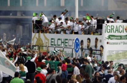 Los aficioandos aplauden a los jugadores del Elche, transportados en un autobús durante las celebraciones.