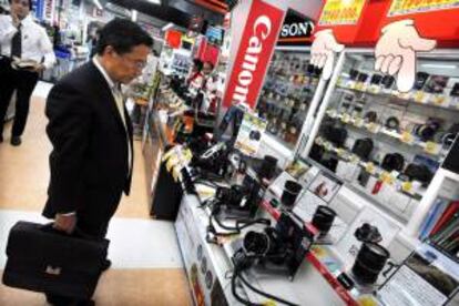 Un consumidor japonés mira las cámaras de fotografía expuestas en una tienda de electrónica en el centro de Tokio, Japón. EFE/Archivo