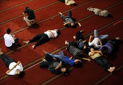 Jóvenes musulmanes descansan sobre el alfombrado de la mezquita de Istiqlal, en Jakarta