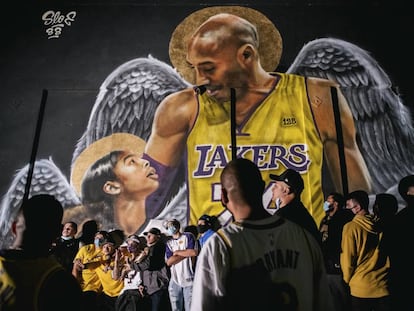 <b>Los Ángeles no olvida.</b> Aficionados de los Lakers se retratan junto a un mural de Kobe Bryant y su hija Gianna, fallecidos en un accidente de helicóptero el 26 de enero de 2020. Tras la muerte del astro del baloncesto, la ciudad de Los Ángeles se llenó de murales como este en su memoria. La imagen fue tomada el 11 de octubre, después de que los Lakers derrotaran a los Heat de Miami en las finales de la NBA.