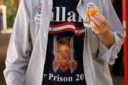 Un hombre viste una camiseta de Hillary Clinton encarcelada mientras come un sandwich, en un mitin del candidato republicano Donald Trump en Augustine, Florida (EE UU) el 24 de octubre.