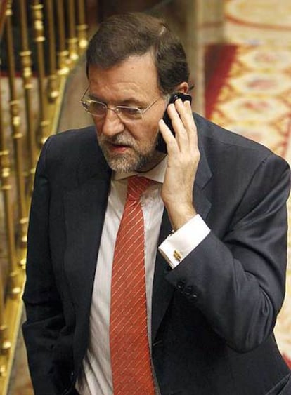 Rajoy habla por teléfono ayer en el Congreso.