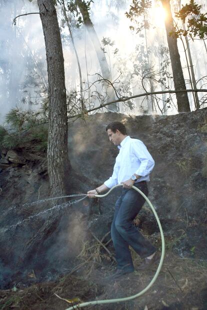 Alberto Núñez Feijóo, en un incendio en Meis (Pontevedra) en 2006 con mocasines y una manguera de jardín. Entonces estaba en la oposición. 