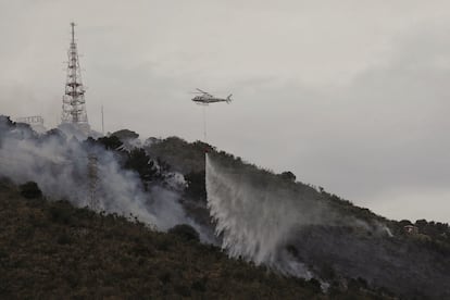Un helicóptero de los bomberos, sobre el incendio en Collserola, este lunes.