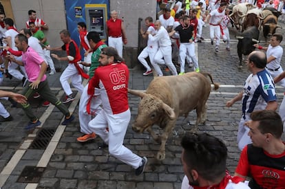 Un corredor esquiva a uno de los toros durante el quinto encierro de San Fermín.