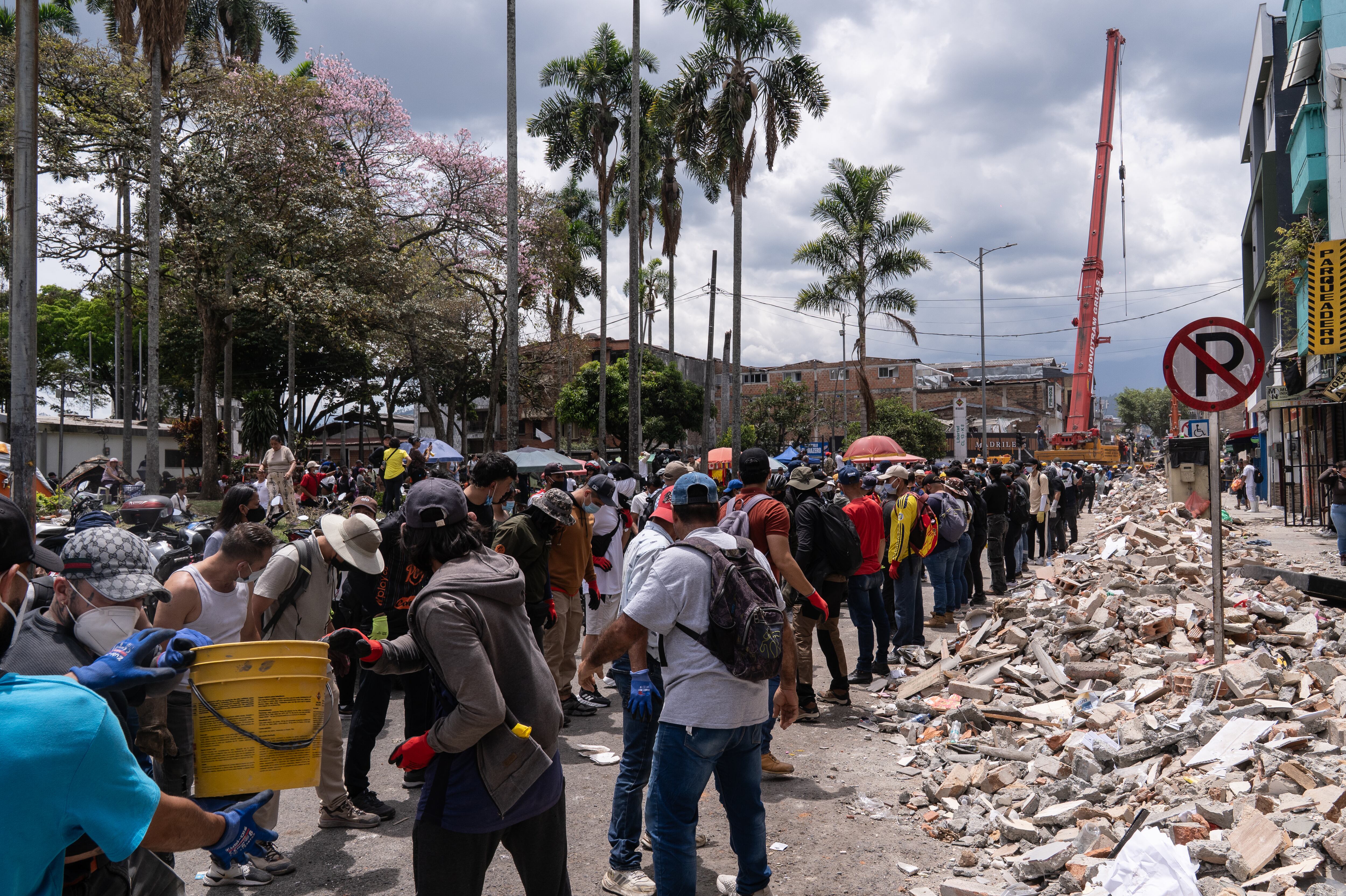 Cientos de personas trabajan para retirar escombros de un hotel colapsado.