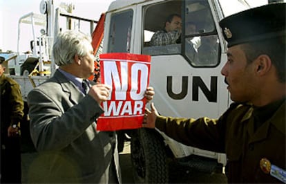 Un diputado alemán muestra en Bagdad un cartel contra la guerra al paso de un vehículo de inspectores de la ONU.