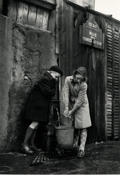 Niños cogiendo agua de una fuente rue des Terres-au-Curé, París. 1954