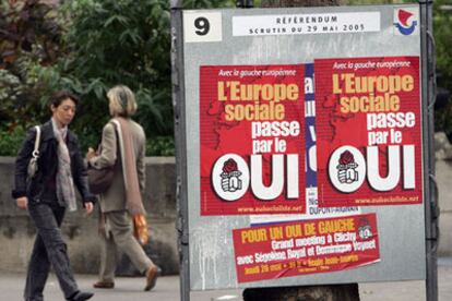 Dos mujeres pasan junto a carteles a favor del <i>sí</i> a la Constitución europea en una calle de París.