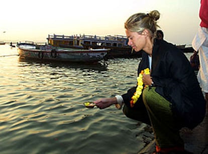 Una mujer echa pétalos de flores en el río Ganges, en memoria de George Harrison.