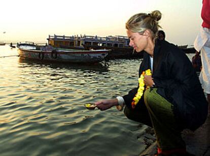 Una mujer echa pétalos de flores en el río Ganges, en memoria de George Harrison.