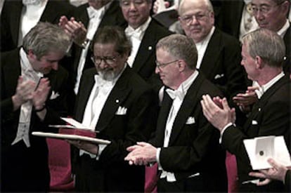 V. S. Naipaul, en el centro, junto al nobel de Medicina, Paul Nurse, a la izquierda, y los de Economía, George Akerlof y Michael Spence, a la derecha.