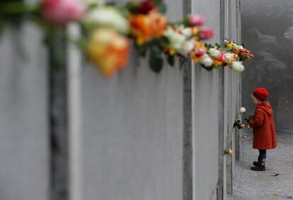 Uma criança coloca uma rosa no memorial do muro de Berlim em Bernauer Strasse, durante uma cerimônia que marcou o 25º aniversário da queda do muro de Berlim (Alemanha), em 9 de novembro de 2014.