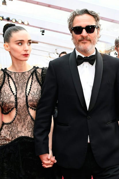 ROONEY MARA Y JOAQUIN PHOENIX. Otra pareja tan discreta como fascinante. Ella, nacida en la opulencia y descendiente de dos de las familias más poderosas de Estados Unidos. Él, hijo de hippies errantes y marcado por la trágica muerte de su hermano de 23 años. Se conocieron en el rodaje de Her, en 2013, pero por aquel entonces Mara mantenía una relación con el director Charlie McDowell (actual marido de Lily Collins). Tres años más tarde volvieron a coincidir en el plató, en María Magdalena, y desde entonces no se han separado. Tienen un hijo de un año al que pusieron de nombre River, como el difunto hermano de Phoenix.