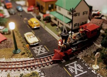 Una locomotora de juguete marcha sobre una maqueta de los años cincuenta.