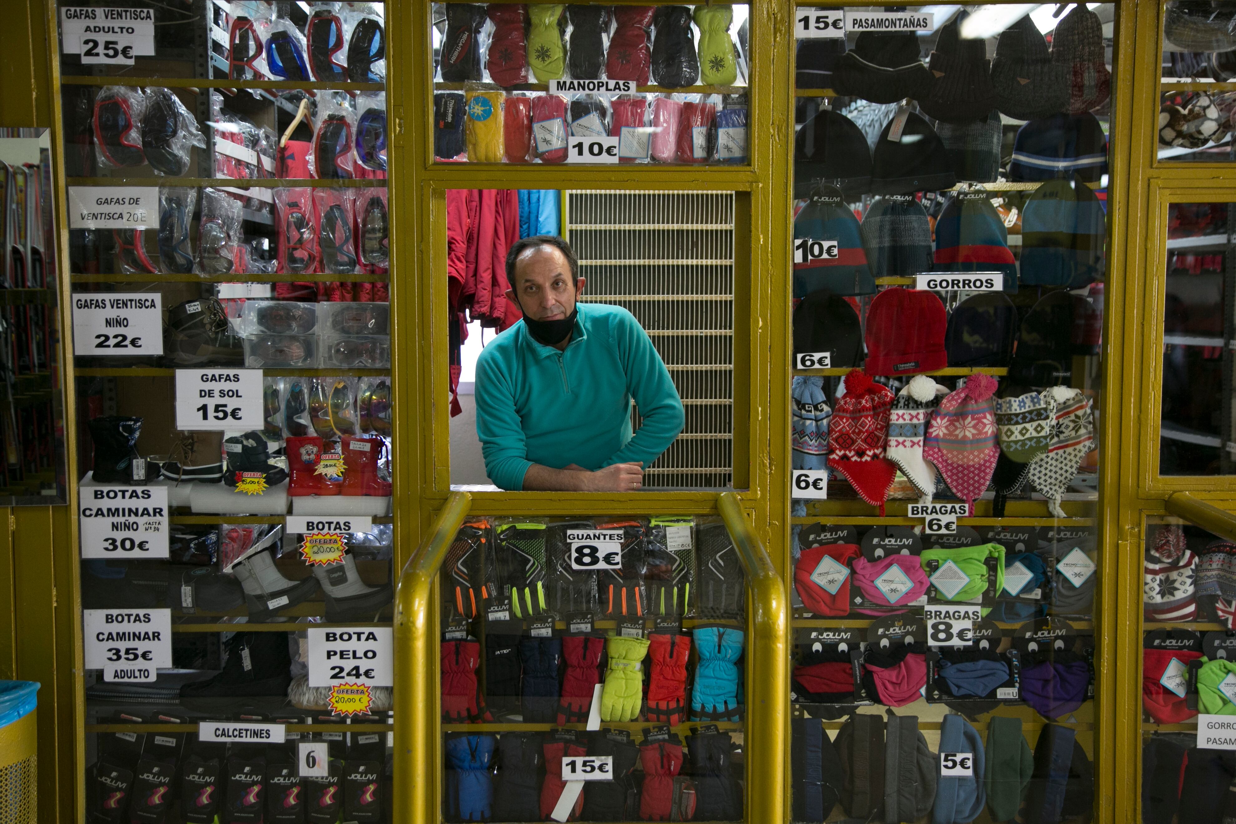 Manuel atiende una caseta de alquiler de trineos y esquís y de venta de guantes y gorros.