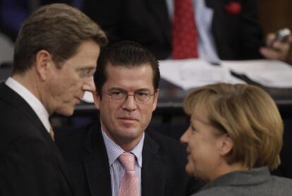 La canciller Merkel, el ministro de Defensa, Guttenberg (centro), y el de Exteriores, Westerwelle.