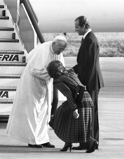 La reina Sofía besa la mano del papa Juan Pablo II en presencia del rey Juan Carlos a pie de escalerilla en el aeropuerto de Barajas. El recibimiento fue austero y ordenado, europeo y ordenado. Por primera vez tras 15 viajes oficiales fuera de Italia, la prensa internacional no protestó.