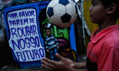 Dos ni&ntilde;os juegan en Brasil ante grafiti contra la corrupci&oacute;n.