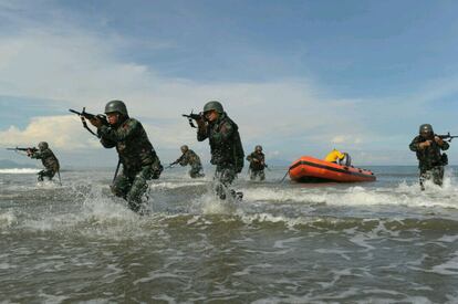 Las tropas del comando militar indonesio mantienen sus rifles listos en su llegada a la playa de Kajhu, en Banda Aceh, durante un simulacro antiterrorista. 