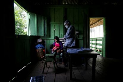 Un miembro del equipo médico de las Fuerzas Armadas de Brasil examina a una mujer del grupo étnico indígena Yanomami.