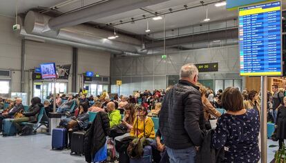 Decenas de viajeros esperan en el aeropuerto de Lisboa a que salgan sus vuelos.