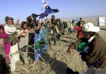 Un paquistaní lanza ropa a refugiados afganos del campo de Chamán, en una imagen de archivo.