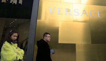 Un grupo de personas camina frente a una tienda de lujo en Pek&iacute;n (China), el 25 de febrero de 2016.