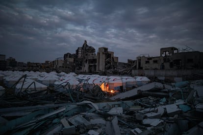 Palestinos encienden este lunes fuego en un campo de refugiados de Ciudad de Gaza.