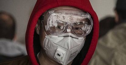 Un hombre se protege con unas gafas y una mascarilla en el aeropuerto de Pekín (China).