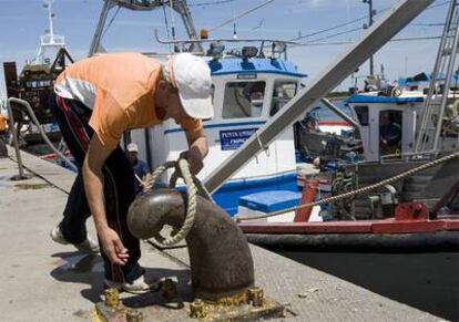 Un pescador amarra un barco de la flota andaluza de arrastre en el puerto de Huelva.