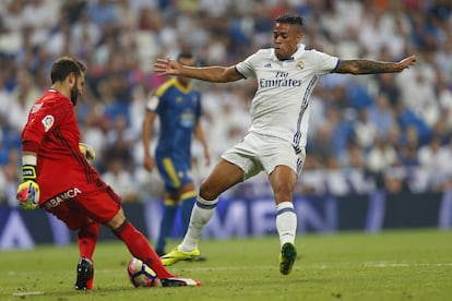Mariano (d) del Real Madrid intenta hacerse con el balón en posesión del portero del Celta de Vigo, Sergio Álvarez.