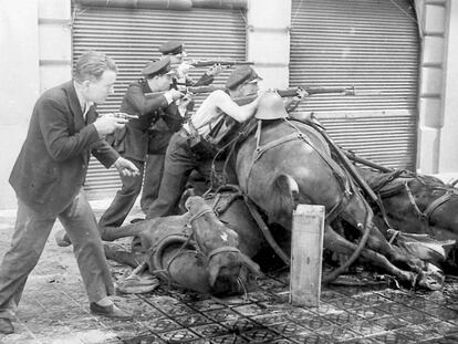 Un grupo de guardias de asalto apostados tras unos caballos muertos como barricada