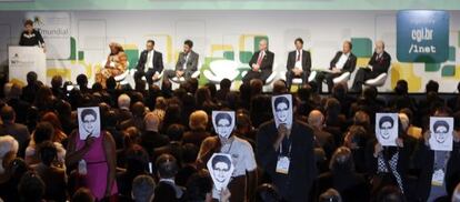 Asistentes a la cumbre de Internet de Sao Paulo muestran fotos de Edward Snowden durante la intervención de Dilma Rousseff.