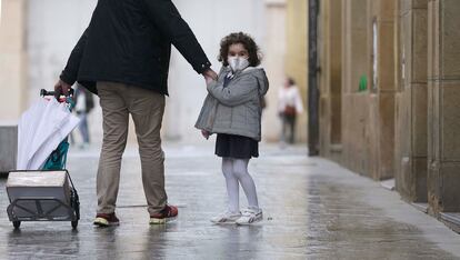 Una niña pasea con un adulto, el lunes 20 de abril en el centro de San Sebastián / Javier Hernández