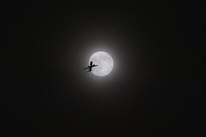 La silueta de un avión en pleno vuelo que parece dirigirse a la superluna vista desde Kunming, al suroete de China.