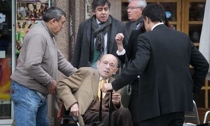 Fèlix Millet, en la silla de ruedas, junto a su asistente y su abogado; al fondo, Jordi Montull.