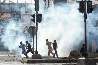 Simpatizantes del partido Tehreek-e-Labbaik Pakistan (TLP) se dispersan después de que la policía disparara gases lacrimógenos durante una protesta contra la detención de su líder que pedía la expulsión del embajador francés por las representaciones del profeta Mahoma, en Lahore (Pakistán).