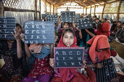 Niños rohinyás aprenden inglés en una escuela coránica en el distrito suroriental bangladesí de Cox's Bazar. Solo uno de cada 15 niños rohinyás aproximadamente tiene estatus de refugiado bajo supervisión del ACNUR. Ese estatus permite acceso formal a educación en escuelas hasta los 12 años. Para la mayoría, hasta 200.000 menores según algunas estimaciones, las madrazas son una de las pocas opciones disponibles. Algunos expertos temen que la vulnerabilidad de la comunidad unida al sesgo ideológico de algunos de estos centros se conviertan en caldo de cultivo para el fundamentalismo.