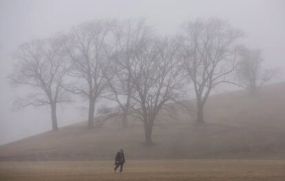 Un hombre camina por el Citadel Hill mientras la niebla cubre la ciudad en Halifax (Canadá). 


