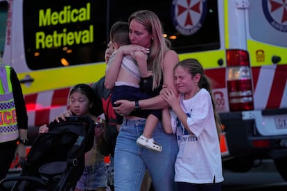Una familia llora mientras abandona el centro comercial Westfield, donde un agresor ha apuñalado a varias personas este sábado en Sídney.