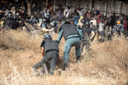 Guardias civiles detienen en Melilla a un migrante poco después de saltar la valla fronteriza que separa España y Marruecos. 