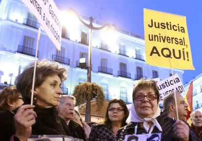 Two women carry banners in support of Judge Garz&oacute;n in Madrid&#039;s Puerta del Sol square.