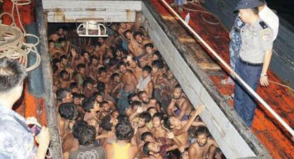 Un policía habla a un grupo de inmigrantes hacinados en un barco pesquero frente a la costa de Rakhine.