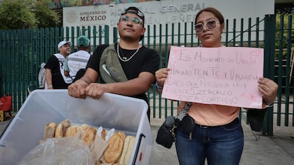 Oscar Alonso y Lizbeth Vargas ofrecen comida a los familiares que esperan fuera del hospital.