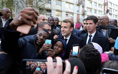 El presidente franc&eacute;s, Emmanuel Macron (c), se fotograf&iacute;a con residentes de Clichy-sous-Bois, a las afueras de Paris, este lunes.