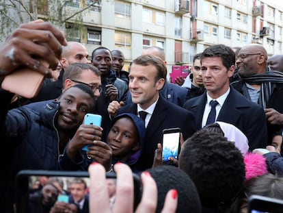 El presidente franc&eacute;s, Emmanuel Macron (c), se fotograf&iacute;a con residentes de Clichy-sous-Bois, a las afueras de Paris, este lunes.