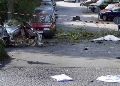 Imagen del coche totalmente destrozado. A la izquierda, el cadáver del fallecido tapado por una sábana.