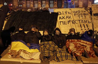 Un grupo de manifestantes descansa durante la madrugada en la plaza de la Independencia de Kiev. 